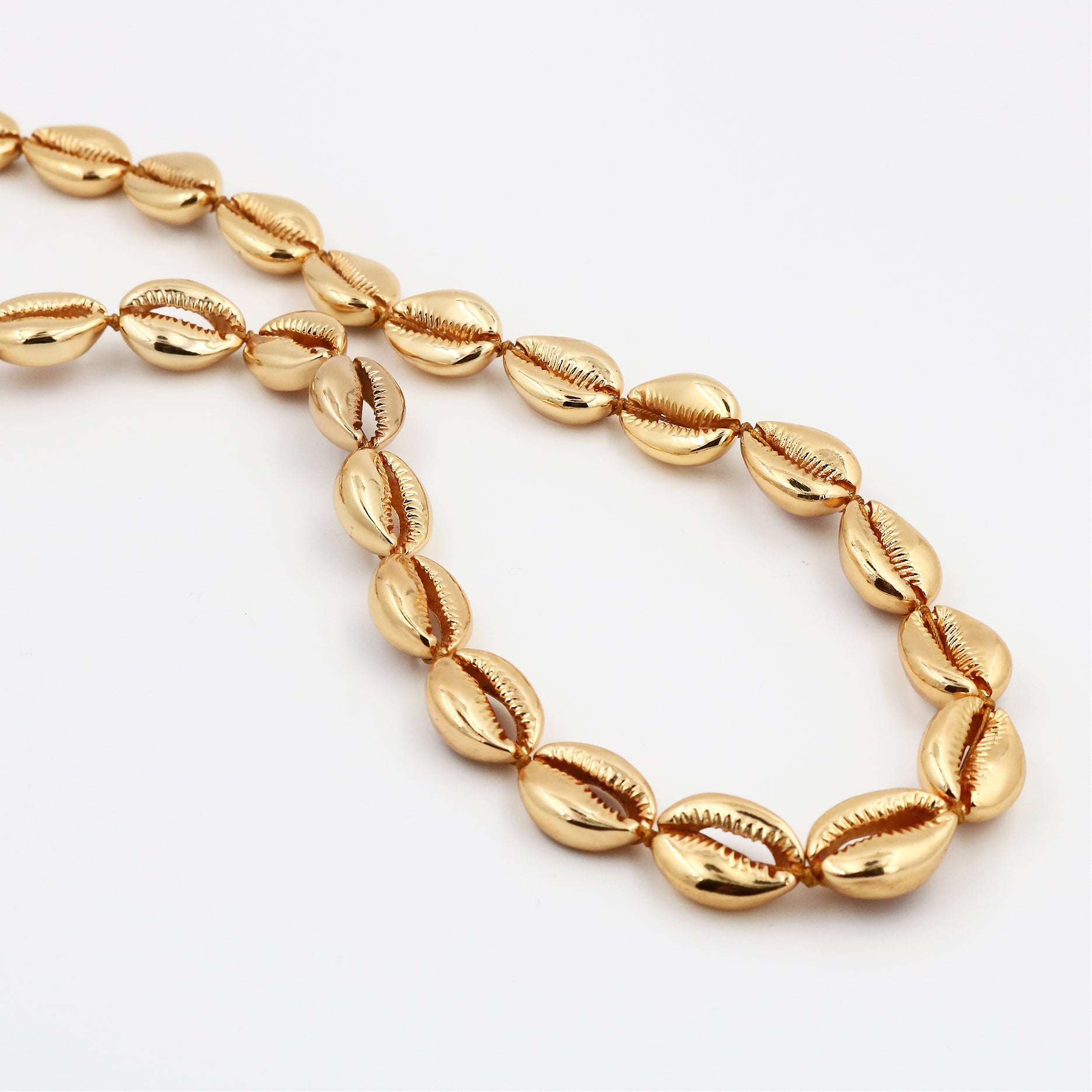 Long gold concha puka necklace by Tohum from Blackbird Collection's sustainable accessories and jewelry