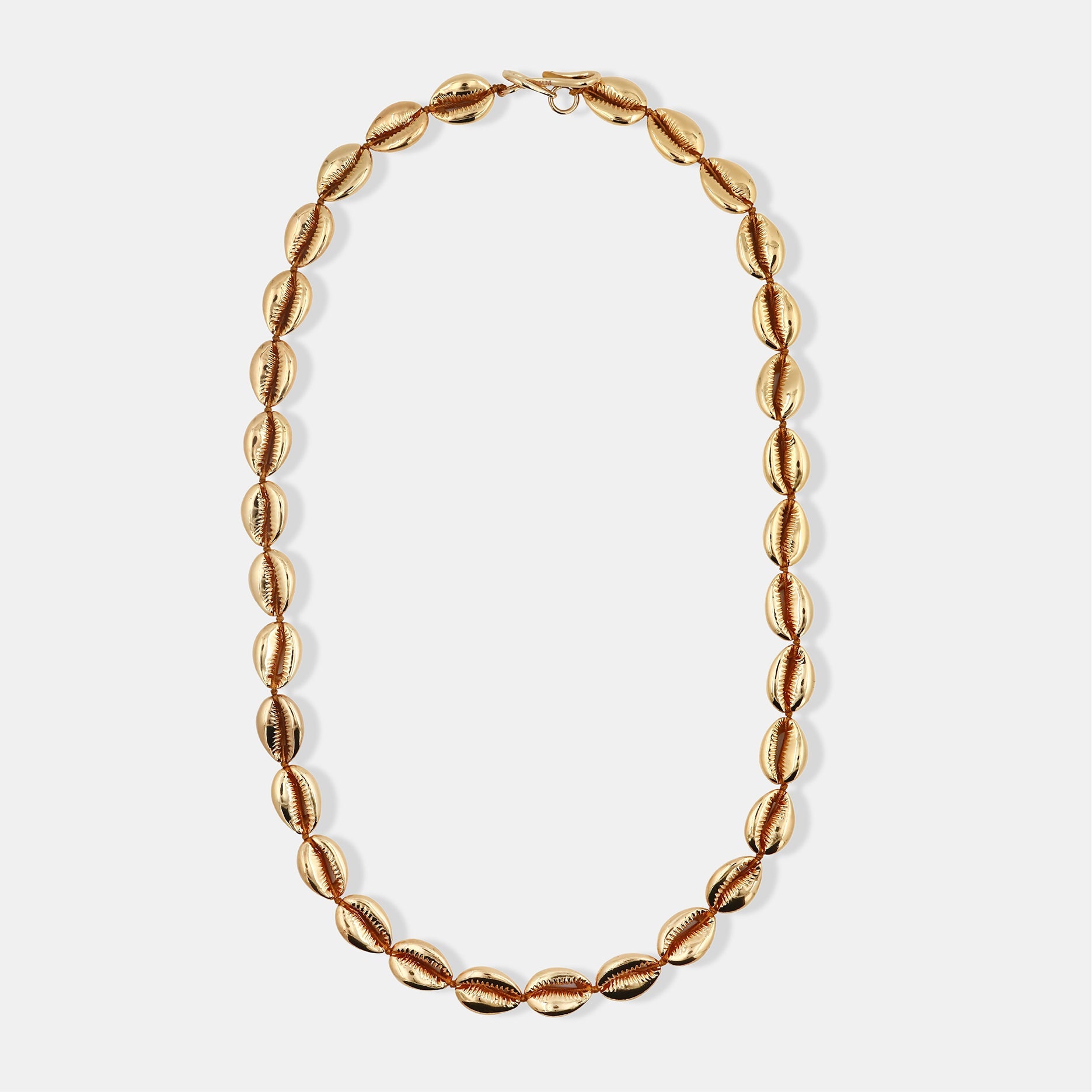 Long gold concha puka necklace by Tohum from Blackbird Collection's sustainable accessories and jewelry